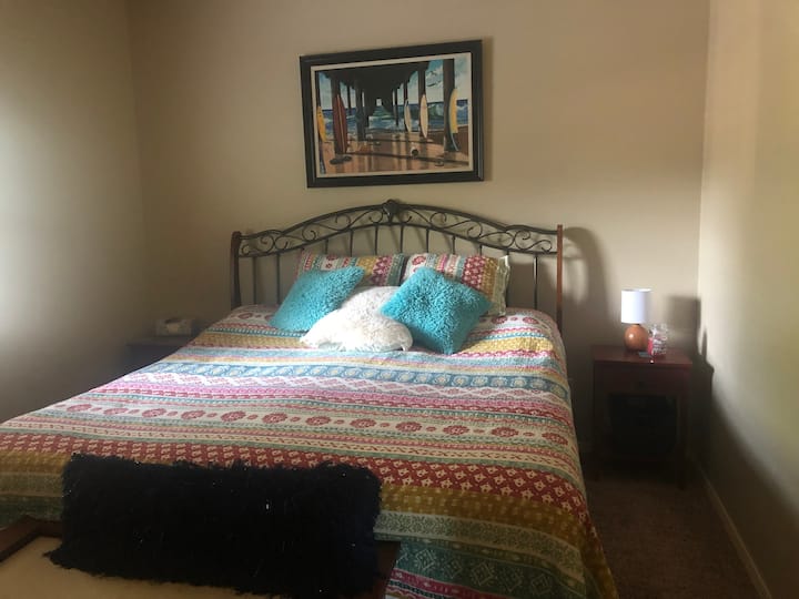 Primárna spálňa má manželskú posteľ s nočnými stolíkmi a stropným ventilátorom. 