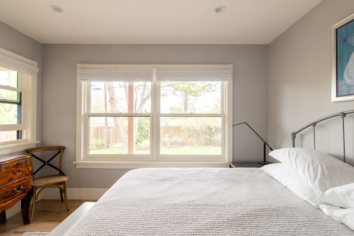 חדר שינה עם מיטת קינג סייז מאחורי הבית. 