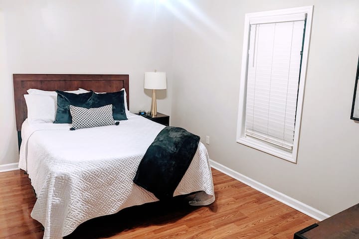 ห้องนอนใหญ่พร้อมโซฟาขนาดควีนไซส์ห้องน้ำเต็มรูปแบบส่วนตัวที่แนบมาตู้เสื้อผ้าหลักแบบวอล์กอินและโทรทัศน์ที่มีโรคุ  