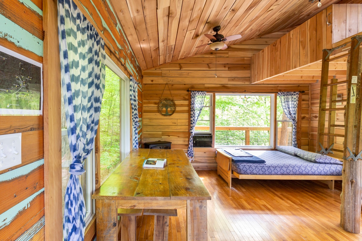 Four giant windows and two loft windows allow for plenty of natural light and views of the forest.