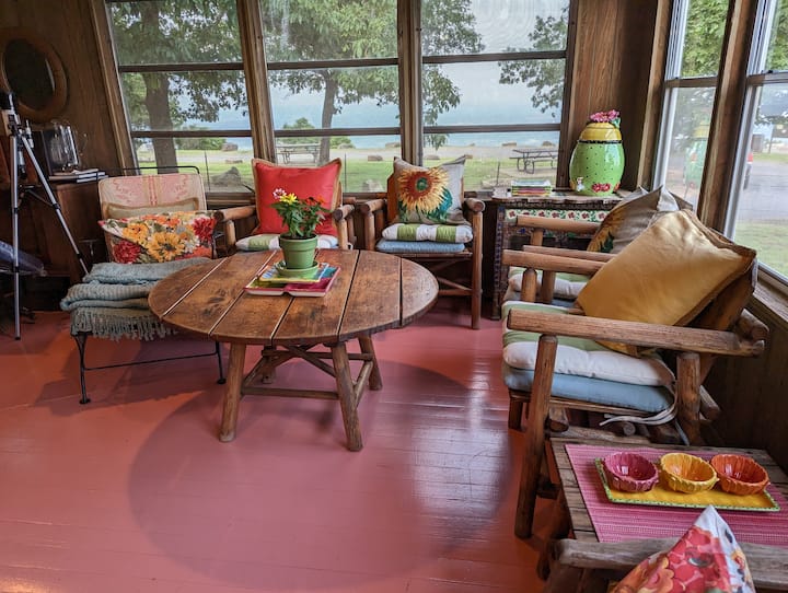 Ден, Пролет, 2023 година, гледа кон исток.  Лево има корпи полни со загатки, игри и книги.  Исто така, ова е складиште за сите перничиња за надворешните столови и шезлонги, чадори и крпи за плажа. 