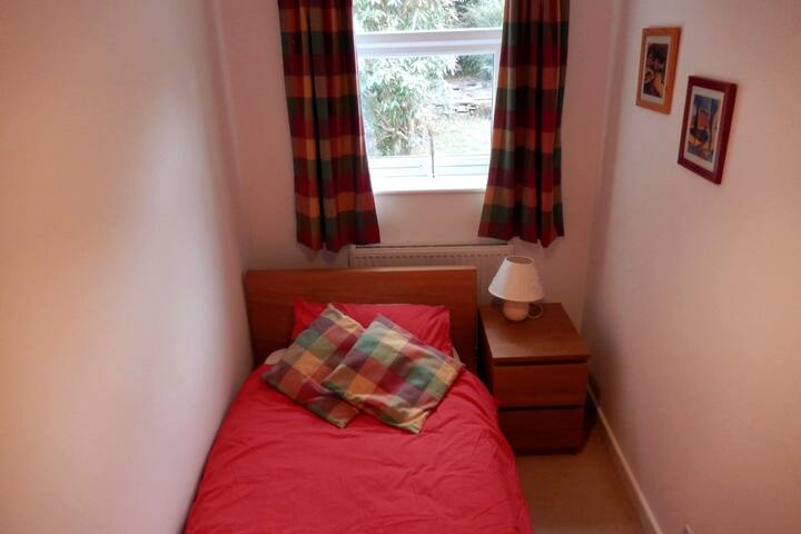 Camera da letto con letto singolo e vista sul giardino sul retro