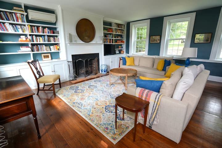 客厅配有两张沙发床和一张古董办公桌。 