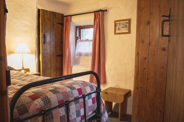 Bedroom Two: Traditional iron-framed bed (Single) with quilt cover, and an ensuite bathroom 