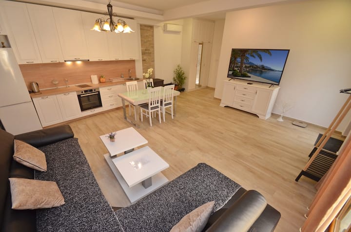 Photo of the whole Room... Living Room with huge TV, Fully equipped Kitchen with Dining Area