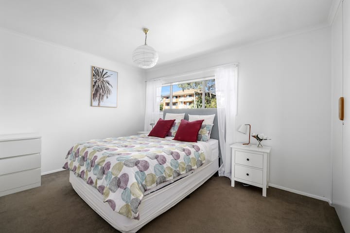 חדר שינה למעלה עם מיטת קווין סייז וטלוויזיה חכמה עם נטפליקס.