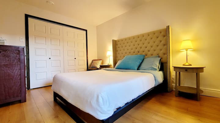 Bedroom 1 w/queen size bed and patio door with access to garden, hot tub, sauna and fire pit