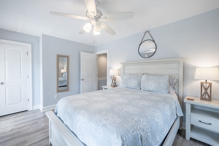 Front bedroom with with queen bed and balcony. 