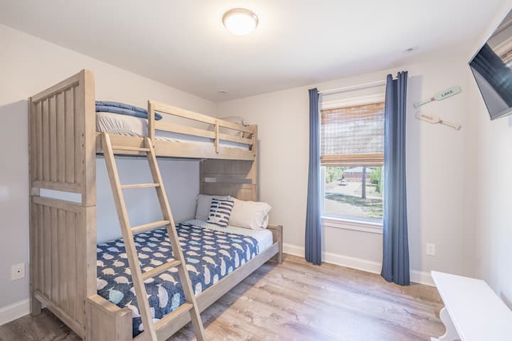 Bunk room with black out curtains and smart television. 