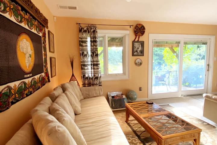 私人露台通往国际主题客厅/图书馆，配有沙发和舒适的躺椅。  装饰包括纪念1987年全非洲运动会的非洲墙壁挂，传统的秘鲁印加帽子，以及您在秘鲁皮萨克体验达人的照片。