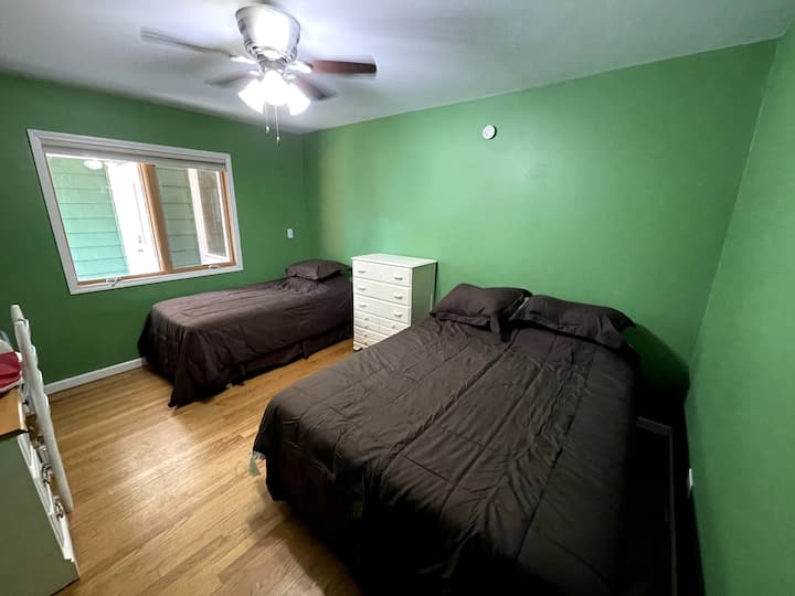 Dormitorio 4 (habitación verde) con cama tamaño queen y dos camas individuales.