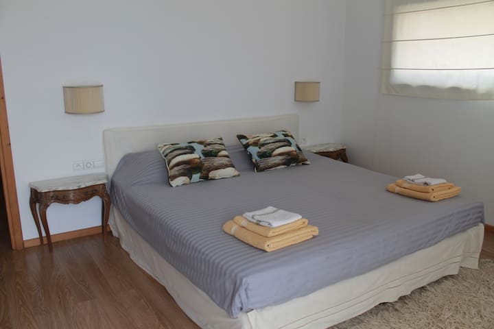 Un dormitorio tamaño king frente al jardín y la piscina