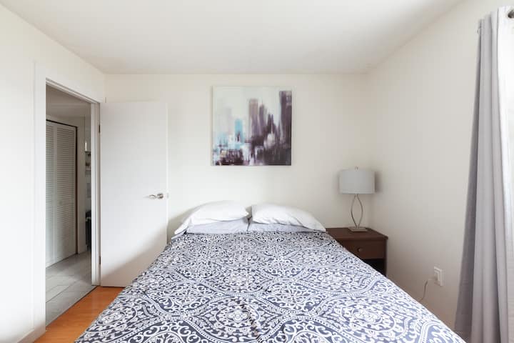 Master bedroom with queen bed, chair, good sized mirror and lots of storage