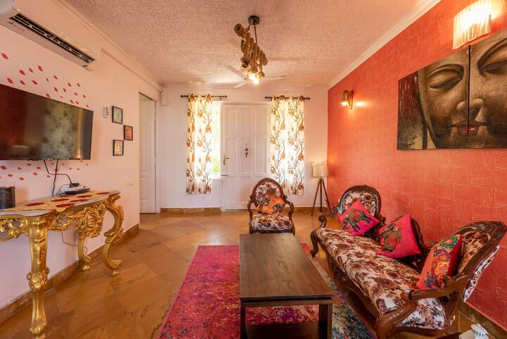 The living area is tastefully furnished with plush sofas and armchairs, creating a cozy space for relaxation and entertainment.