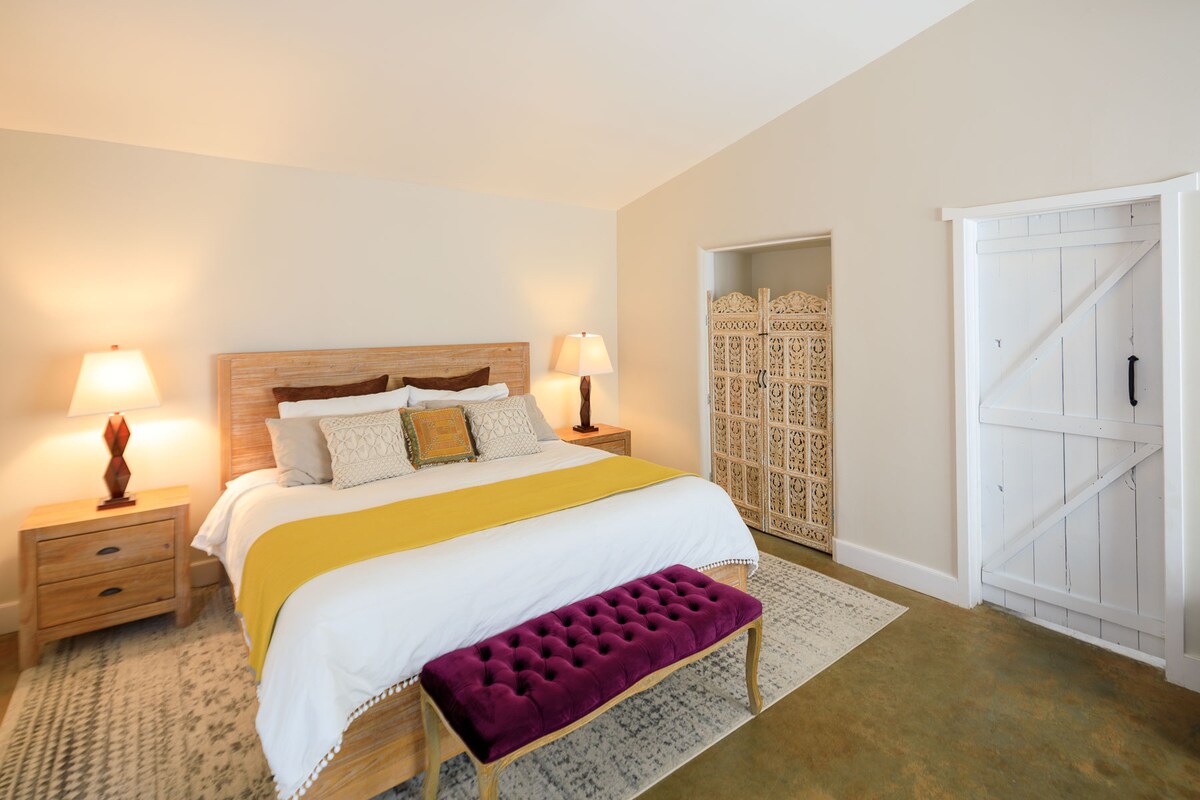 Kitanda cha ukubwa wa mfalme katika chumba cha kulala chenye nafasi kubwa