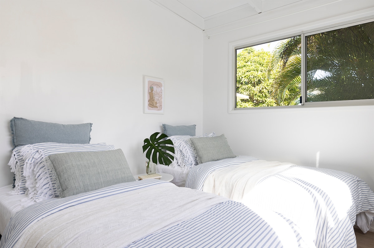 חדר שינה 3 כולל 2 מיטות יחיד רכות של קינג סייז ובנוי במלתחה עם נוף לעצי דקל בחצר האחורית. 