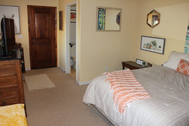 חדר שינה 3 עם טלוויזיה ודלת שמגיעה למרפסת האחורית.