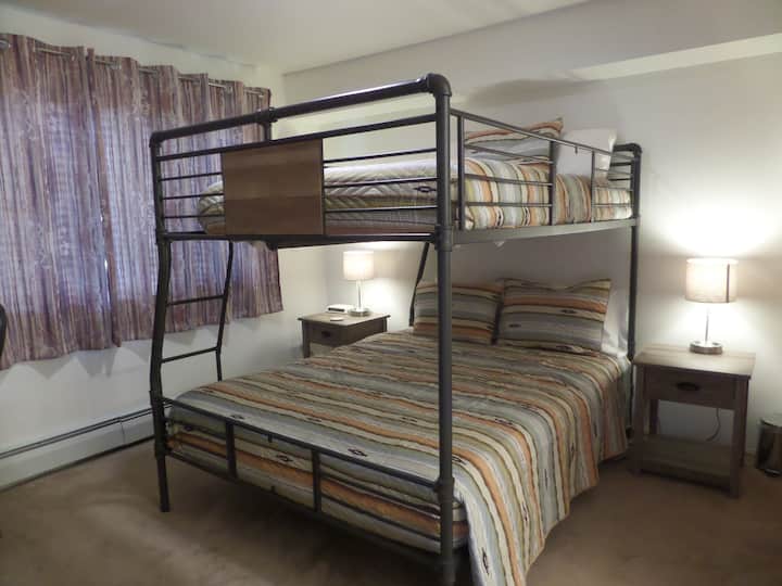 ห้องนอนด้านหลังพร้อมฟูกนอนขนาดใหญ่เหนือฟูกนอนขนาดควีนไซส์