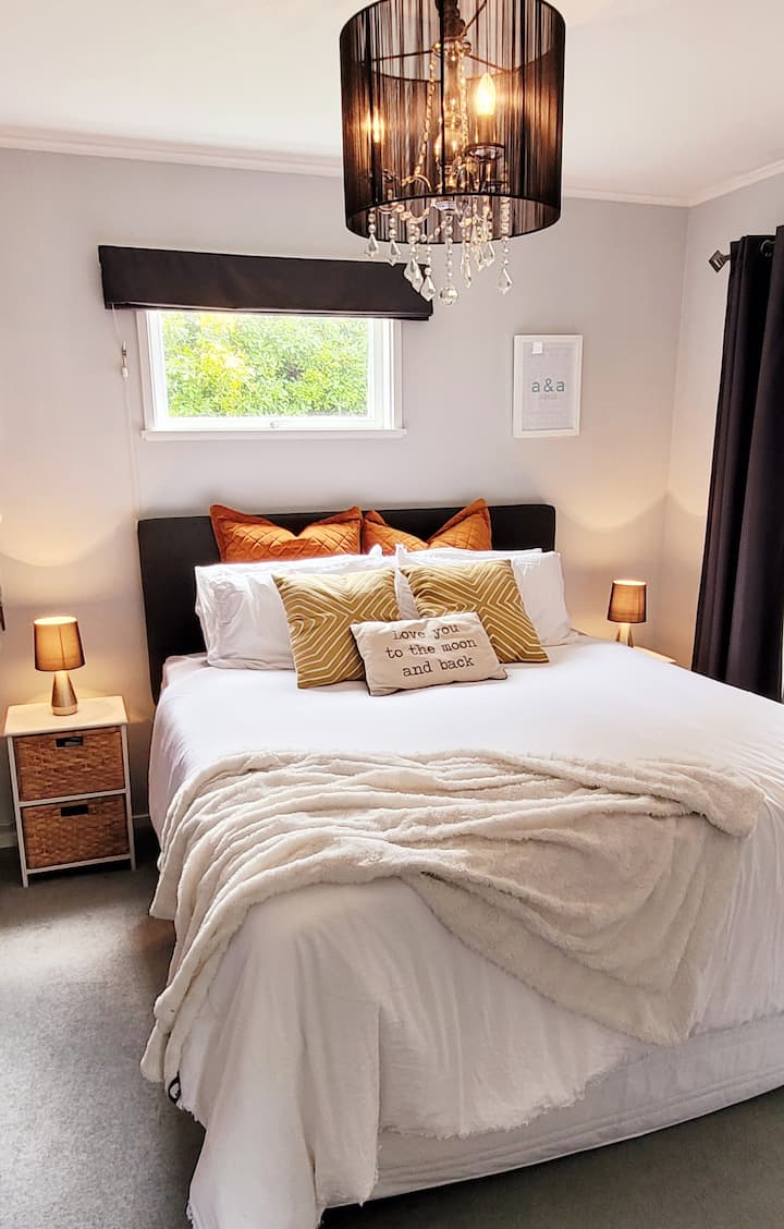 放松的主卧-特大双人床，配有Adairs床上用品和充足的枕头和垫子！