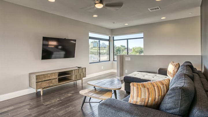 Relájate en una elegante y acogedora sala de estar en el piso superior con un gran sofá cama tamaño queen y pisos de madera.