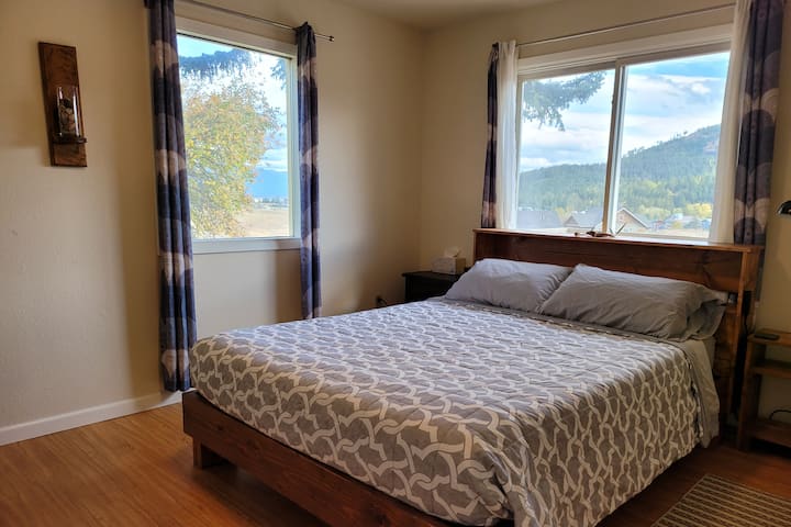 חדר שינה זוגי עם חדר ארונות ושני שולחנות צד עם שקעי חשמל נגישים בקלות בכל צד של המיטה.