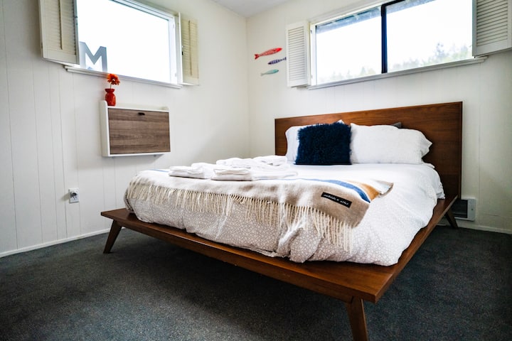 La troisième chambre lumineuse dispose d'un lit Queen West Elm, d'une couverture Pendleton et d'un bureau mural pliant. 