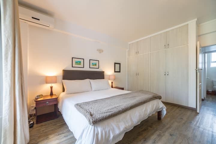Large air-conditioned bedroom with extra-length king size bed, ceiling fan and ample cupboard space.