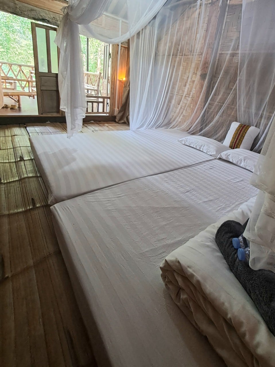 A double room is a simple, small bedroom with 2 single mattresses or 1 double mattress. The room has clean blankets, sheets, pillows, mattresses, fans and mosquito nets. A small balcony with tables and chairs.