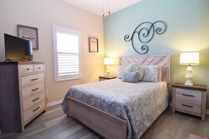 Atractivo dormitorio queen con ventilador de techo y TV inteligente