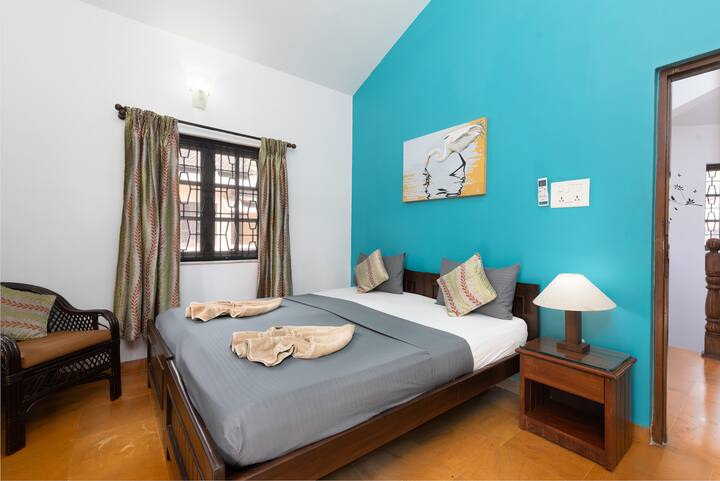 Green bedroom with attached balcony.