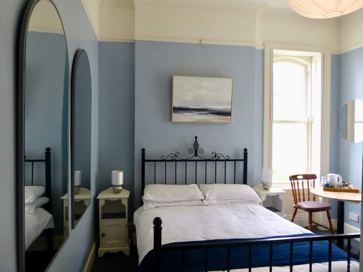 Rum 5 dubbelrum med hög loftsäng för ett äldre barn om så önskas.  Fönstret ser ner på stranden.