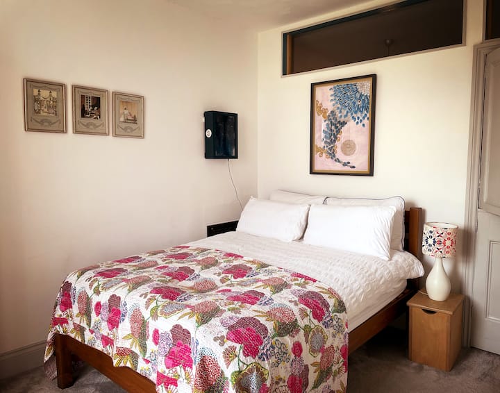 Acogedora cama matrimonial en la habitación blanca.