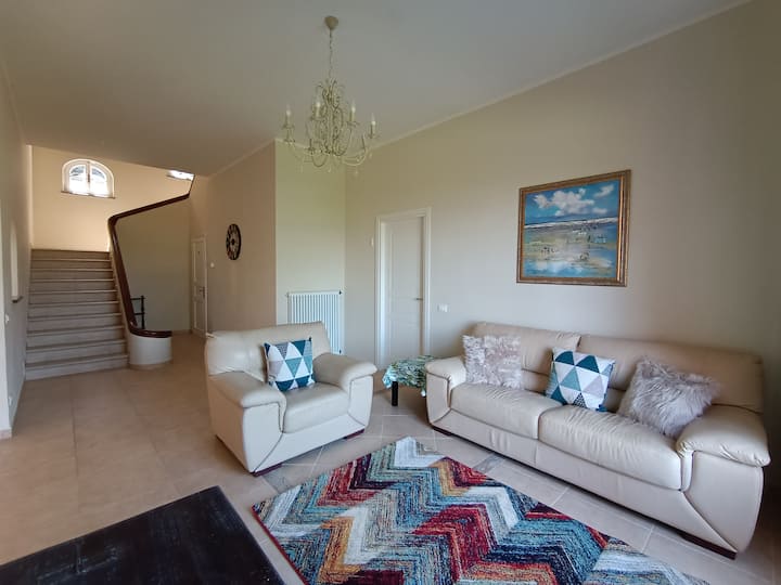 Vila jonë Magnifica është vërtet e rehatshme dhe e organizuar mirë! Hyrja të çon në një dhomë ndenjjeje të rehatshme dhe të rehatshme në të majtë, të mobiluar me divane lëkure ngjyrë bezhë të rehatshme dhe jastëkë të mrekullueshëm dhe një televizor inteligjent për argëtim.