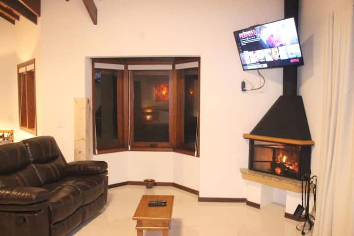 Dhomë ndenjjeje me oxhak dhe televizor kabllor + Netflix.