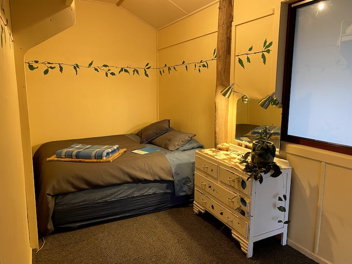 Longer bedroom 2 with a king bed that can convert into two single beds with windows to north and west under verandahs.  The room also has a wider doorway allowing for all abilities access.