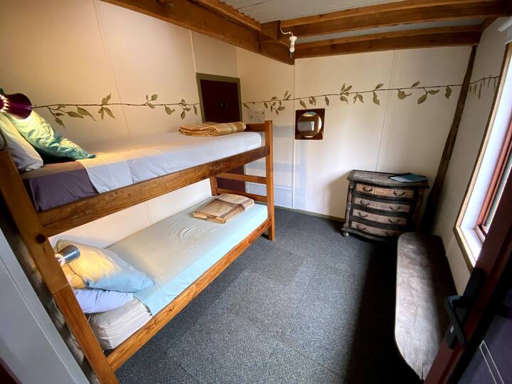Bedroom four with bunks, can be converted to single beds or a queen bed.  The room shares an access corridor with bedroom three (perfect for young ones who wish to sleep near) .  This room has an easterly window shown and a south door onto a veranda