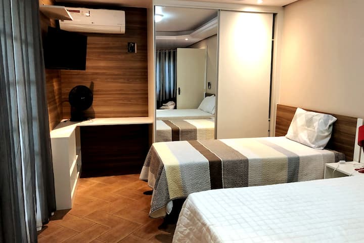 Quarter 2: Room with double bed and single bed, smart TV, hot and cold air conditioning, and balcony with green view. Comfortable and well lit accommodation, perfect for those looking for tranquility with a touch of nature.