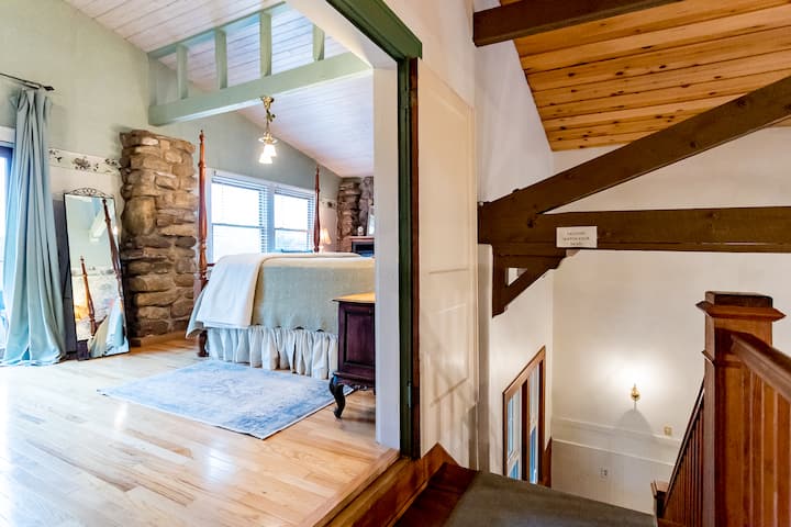 Ngazi zinaelekea kwenye chumba cha kulala cha Hummingbird. Bafu la chumbani na magogo ya gesi. Roshani inayoangalia viwanja vya mbele.