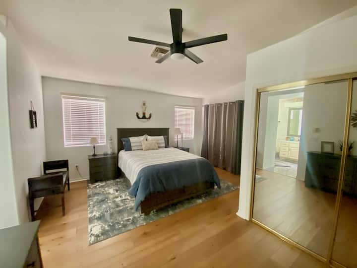 ห้องนอนใหญ่เตียงควีนไซส์ที่สะดวกสบายพร้อมพื้นที่ตู้เสื้อผ้ามากมายและการตกแต่งที่มีสไตล์ 