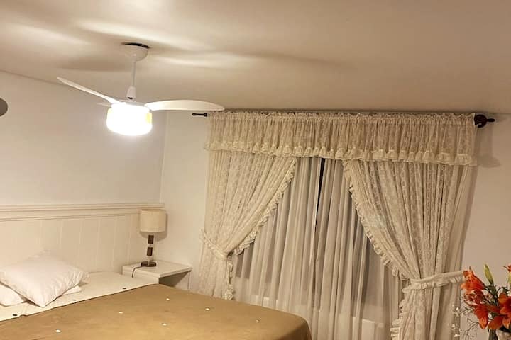 Suite con cama súper king, TV  y ventilador de techo.