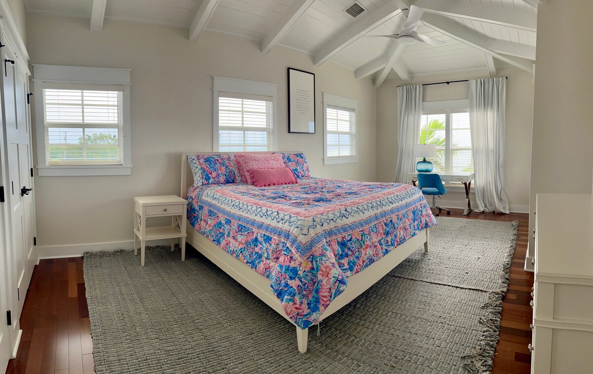 ห้องนอนผู้เข้าพักพร้อมเตียงคิงไซส์ มีโต๊ะเขียนหนังสือและทางเข้าระเบียง