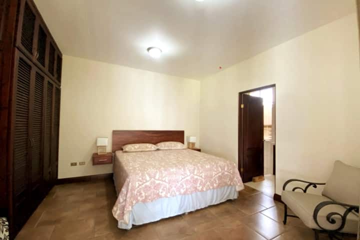 Main room, such as kIng bed, private bathroom, clothes storage and armchairs