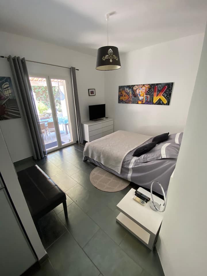 El dormitorio principal, que da directamente a la pérgola y a la zona de la piscina, está equipado con aire acondicionado, vestidor, TV y baño en suite con ducha. Cama tamaño queen (160 cm).