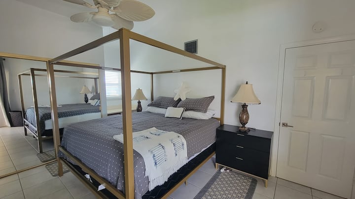 Main bedroom on upper level at #58 Cayman Reef Resort. Light and Bright with a super comfortable  queen size bed and white bed linens.