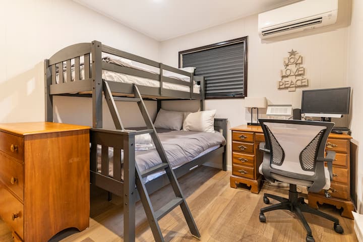 Spavaća soba 3 (desna spavaća soba na glavnoj etaži) s krevetom na obali (pun na dnu i dvostrukim na vrhu) i uredskim stolom s monitorom, priključnom stanicom, tipkovnicom i mišem.