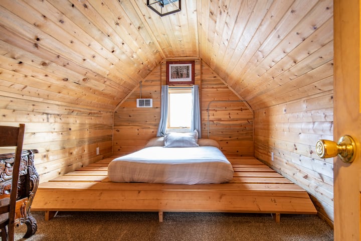 三楼卧室。木质平台上有标准双人床垫。 