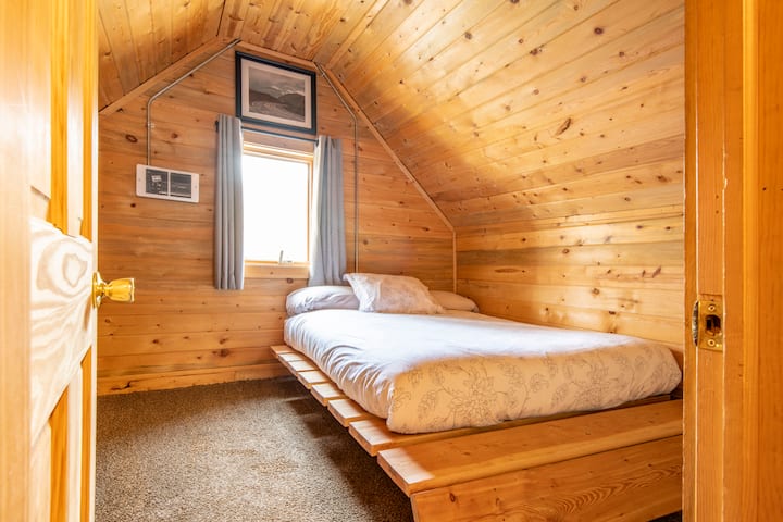 三楼卧室。四周环绕着舌头和缝隙松树，给人一种舒适的山间小屋。