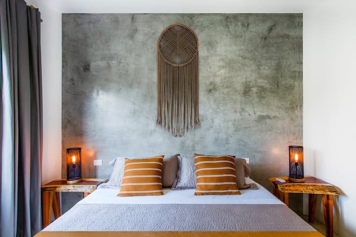 Matelas Sealy king size avec tables d'appoint et lampes de nuit.