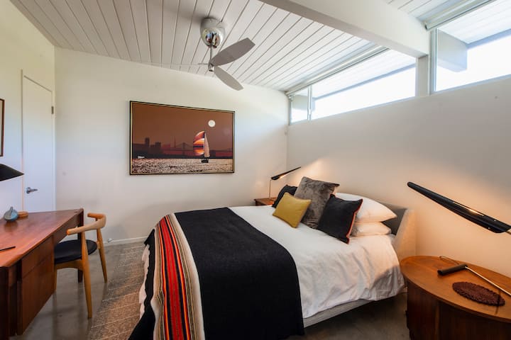 Queen bed in the apartment's bedroom with pocket doors for extra privacy.