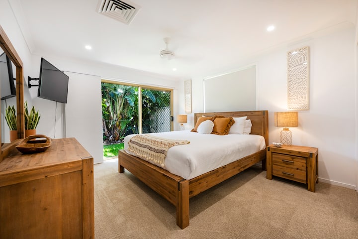 Основна спалня с двойно легло, телевизор, вграден халат и достъп до задния двор.